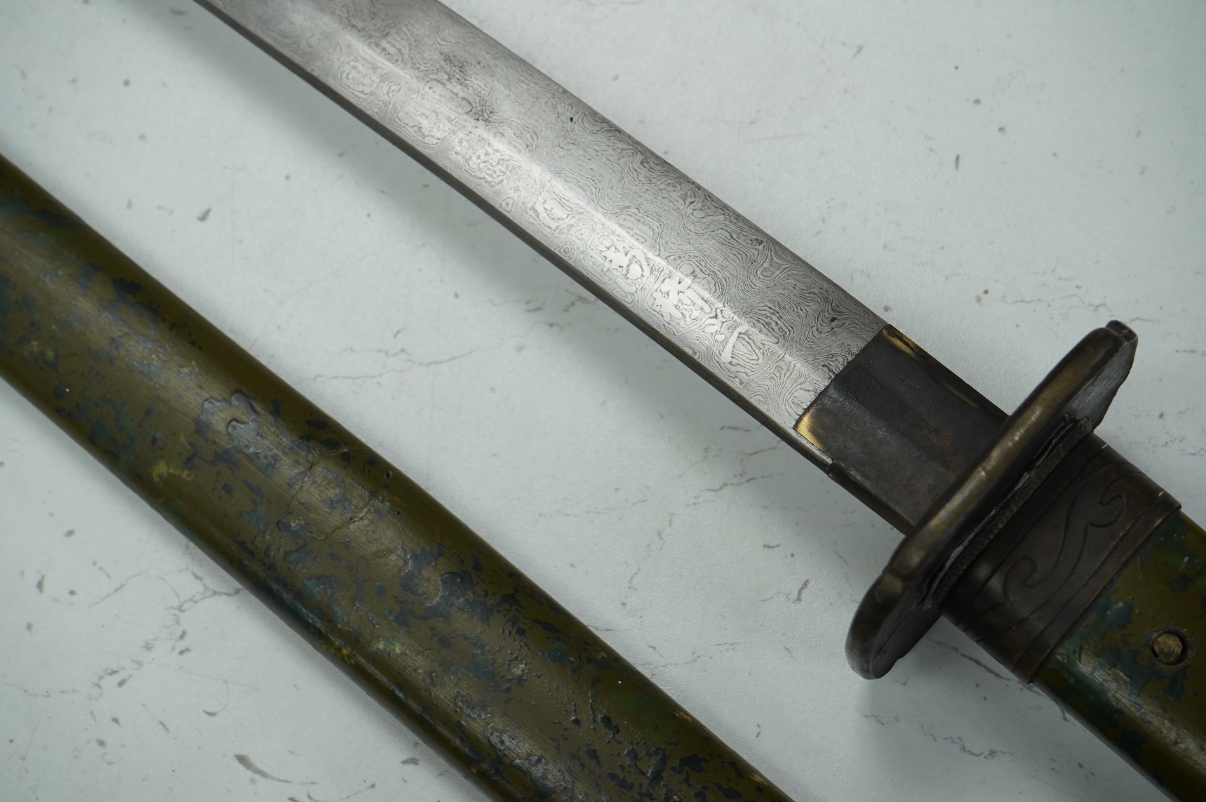 A well-made Chinese copy of a Japanese sword katana, blade etched with wood grain imitation, green painted handle, scabbard with engraved brass mounts